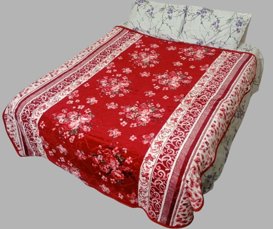 Red floral printed bed blanket on double bed with white floral pillows
