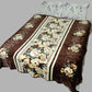 Brown floral bed blanket with cream and yellow flowers on a double bed