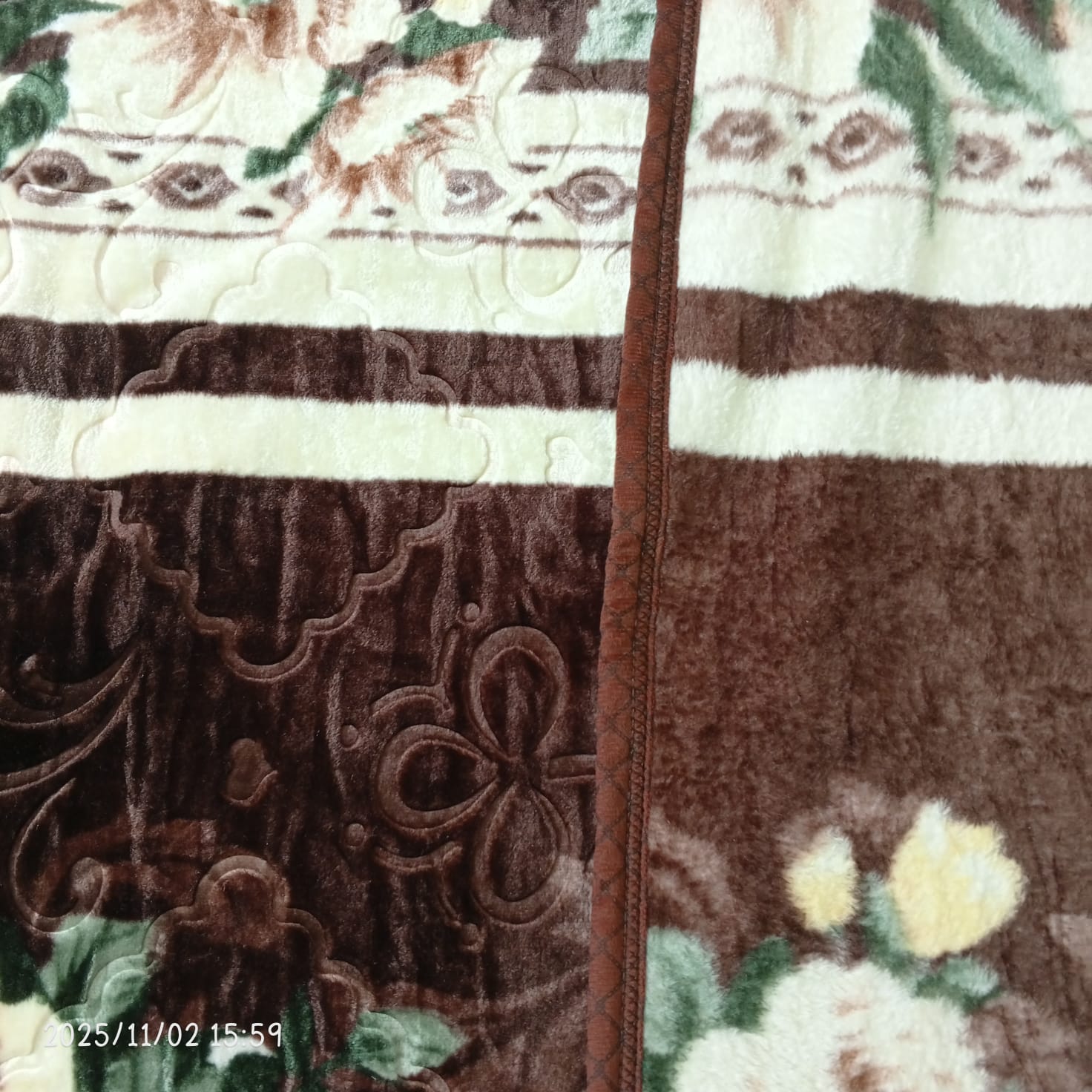 Brown and cream floral patterned fleece blanket with stitched edge and textured designs