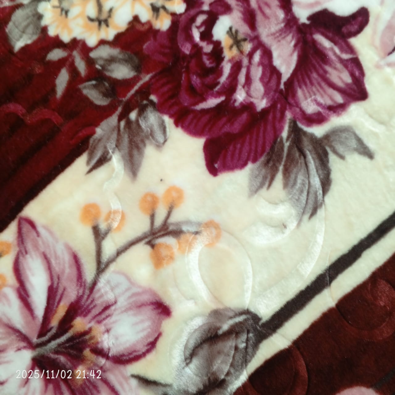 Floral printed velvet blanket with maroon, purple, and beige flower pattern
