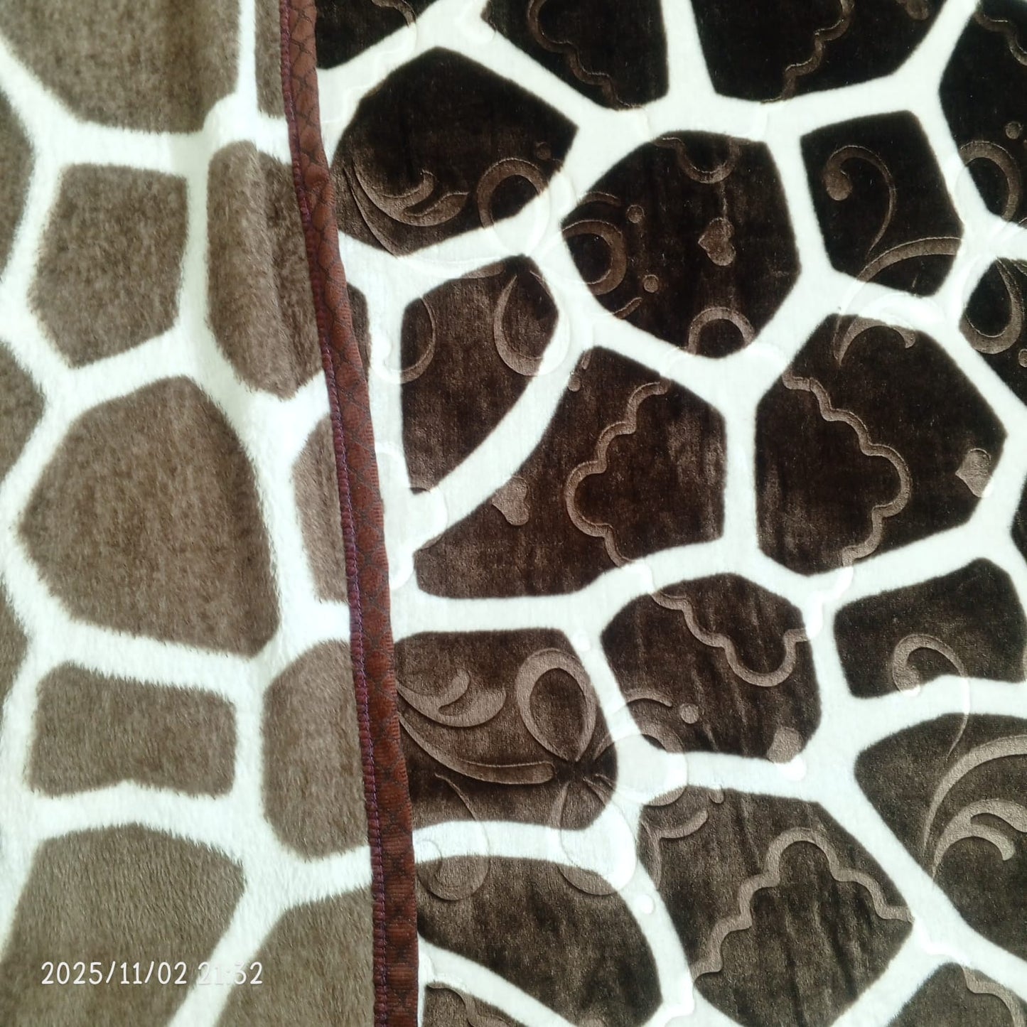 Brown and cream geometric patterned fleece blanket with stitched border detail