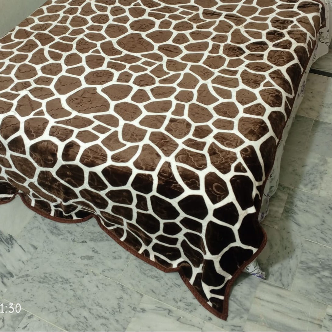 Brown giraffe print blanket on bed over marble floor