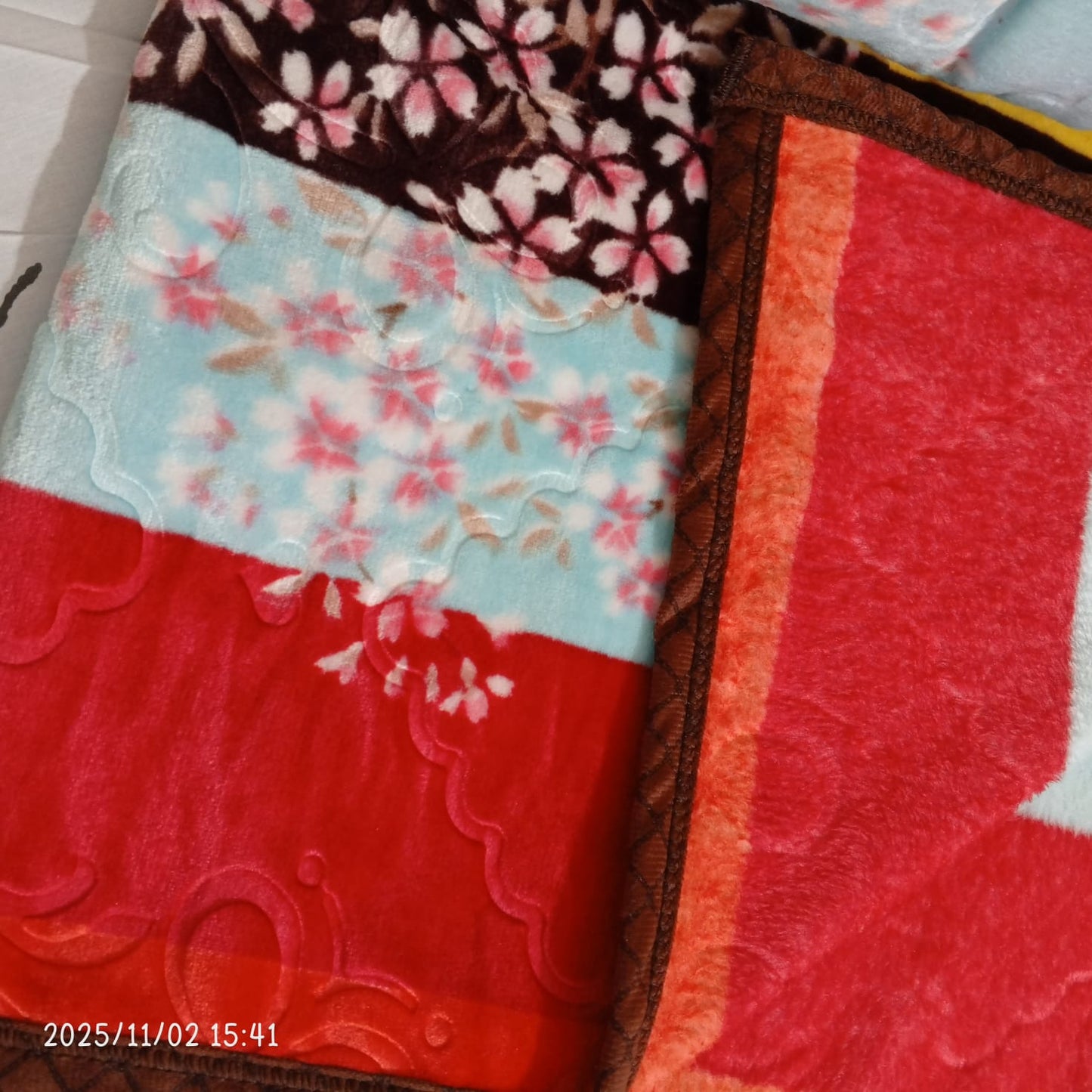 Colorful floral and patterned blankets with red, brown, and blue designs
