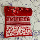 Red floral and patterned blanket on white floral bedsheet